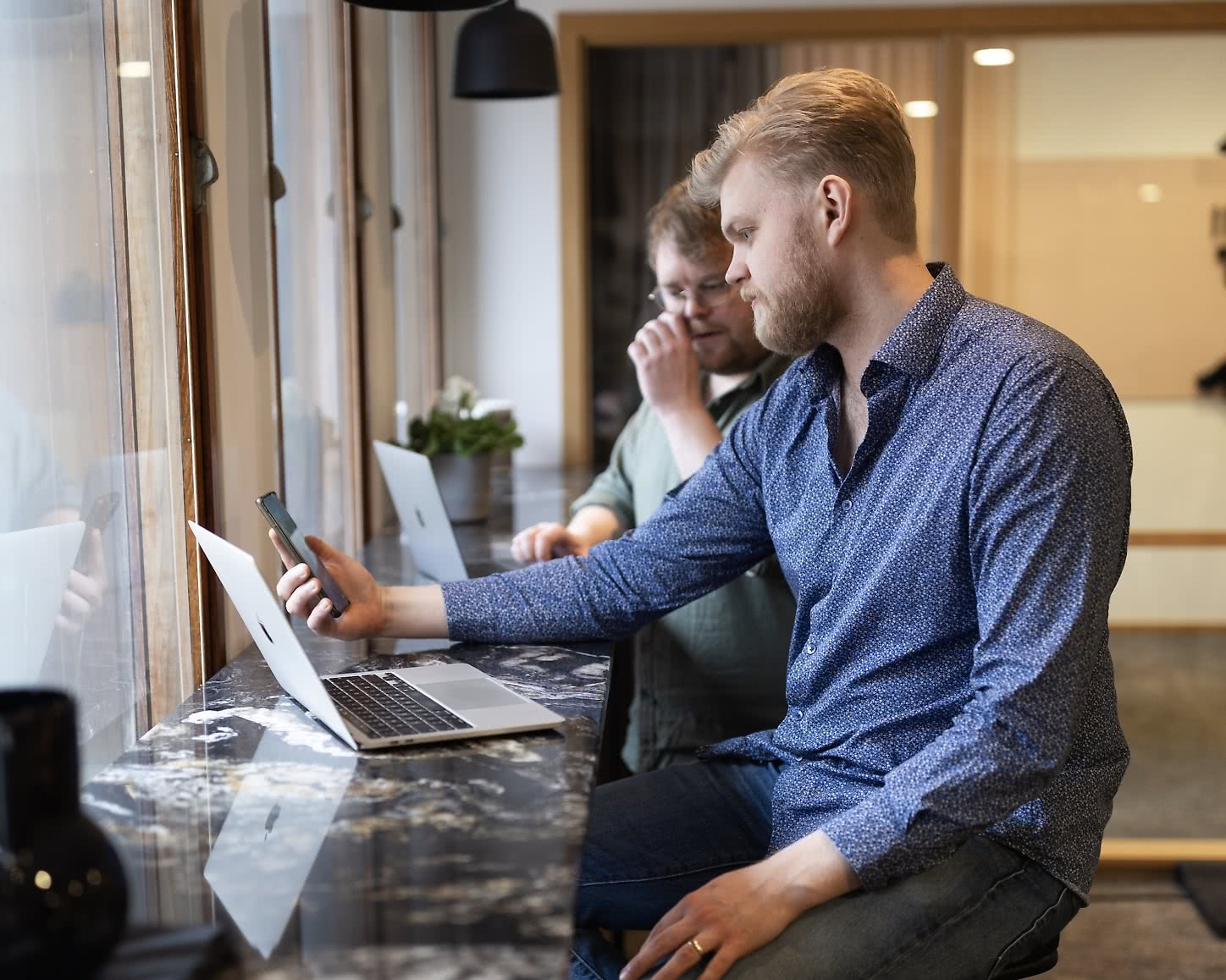 Två utvecklare samarbetar om framtidens e-handel vid en arbetsplats med laptops.
