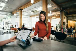 Kund som betalar med kort i en betalterminal