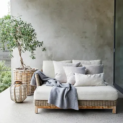 An outdoor sofa with soft white cushions and blankets from Himla