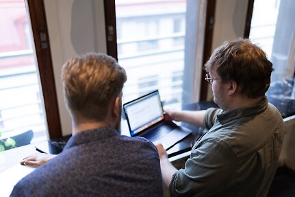 Två medarbetare från Webbhuset arbetar tillsammans vid en laptop, ett exempel på samarbetet bakom skräddarsydd webbdesign och användarupplevelse.