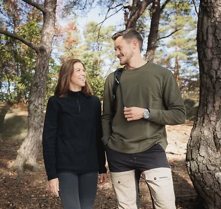 En kvinna och en man i vandringskläder ute i skogen