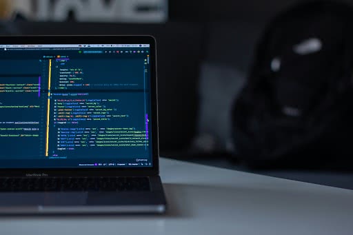 Programmeringskod på en laptop som används för att bygga en digital transformation plattform.